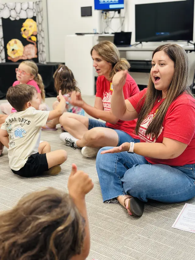Bridge Kids volunteers singing and playing with toddlers in the preschool room