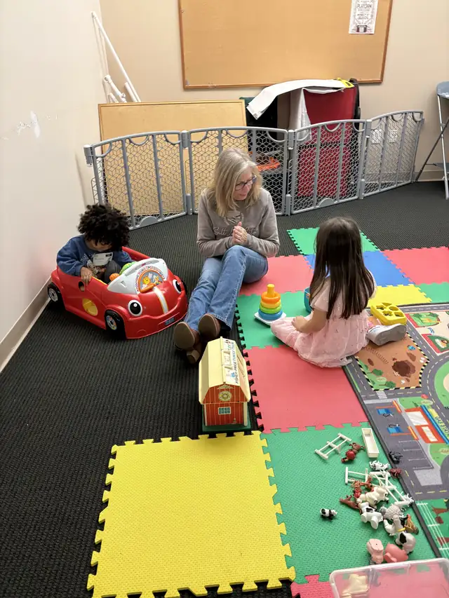 Toddlers playing with cars and foam mats in the Bridge Kids play zone