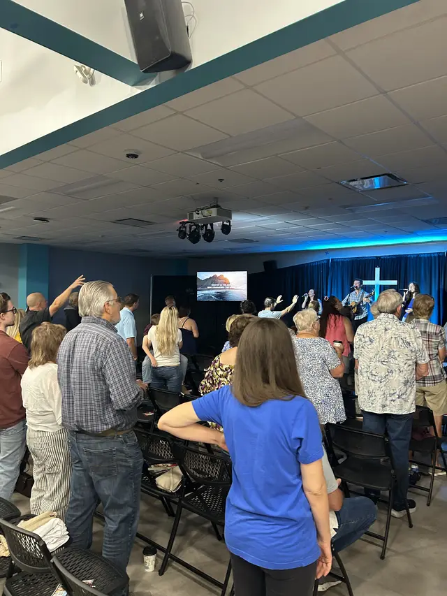 The congregation worshiping with hands raised during a Sunday service